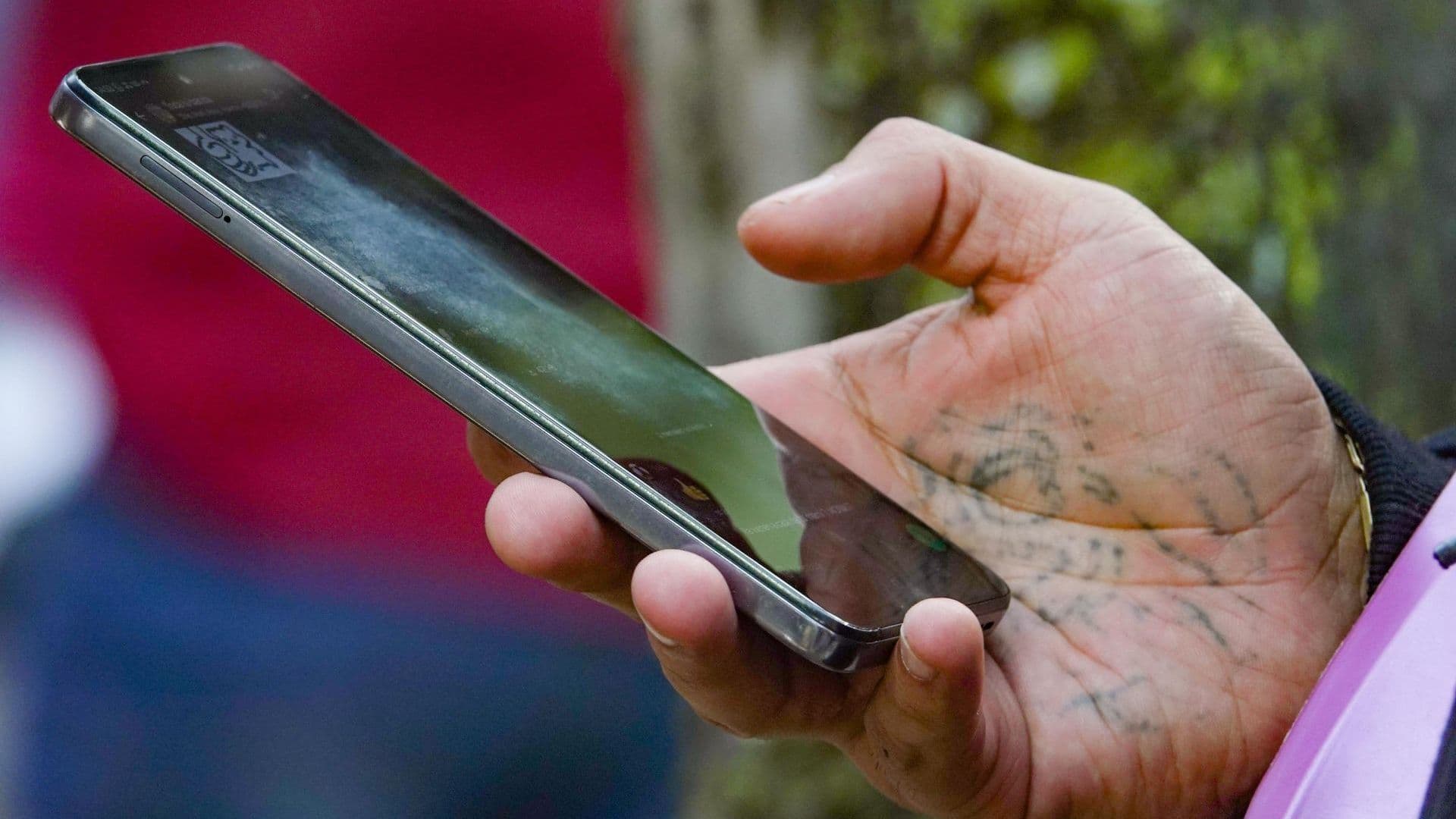 Mano sostiene celular por Registro de Celulares 2026. Alta de Datos Biométricos